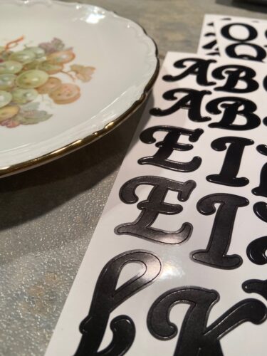Adhesive lettering beside thrifted vintage plate