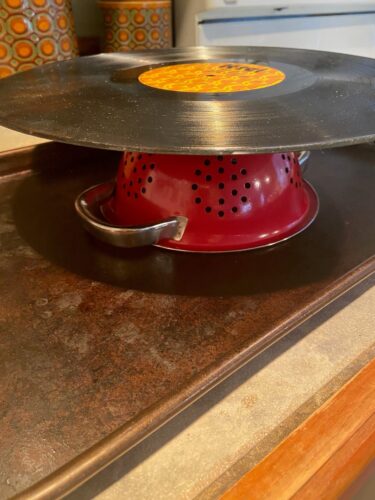 Thrifted vinyl record on top of strainer