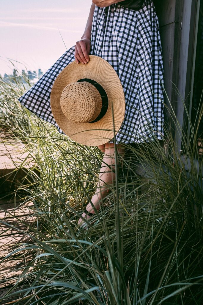 Straw hat being held in tall grass