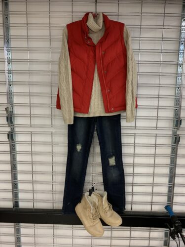 women's winter outfit with red puffy vest and cream turtleneck sweater and denim jeans and cozy winter boots