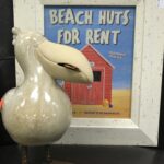 pelican decor alongside a framed summer photo of a beach hut