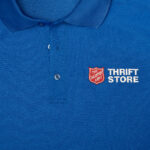 Impact report cover photo of blue Thrift Store employee collared work shirt