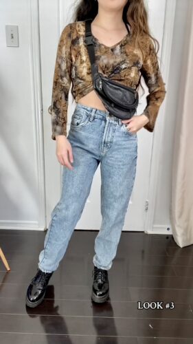 person wearing outfit with patterned top, cross-body bag, and jeans