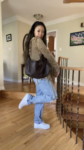 Anna wearing sweater purse and jeans