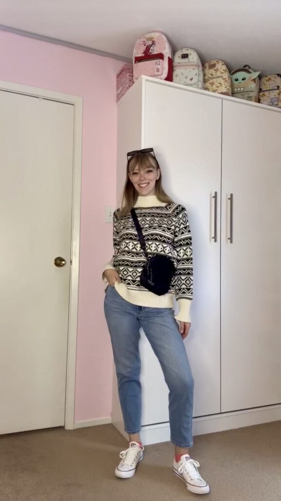Jade wearing a white thrifted knit sweater with denim and crossbody purse