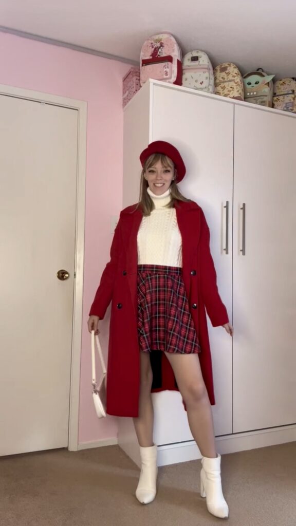 Jade wearing a red thrifted trench coat with beret, plaid skirt, white boots and top