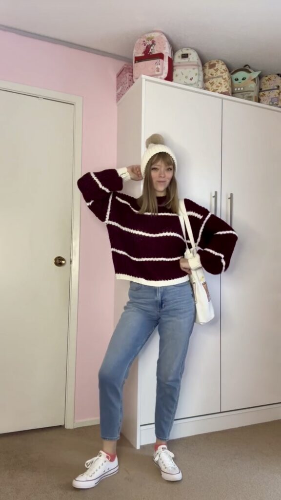 Jade wearing a thrifted striped sweater with winter hat, white purse, shoes, and denim