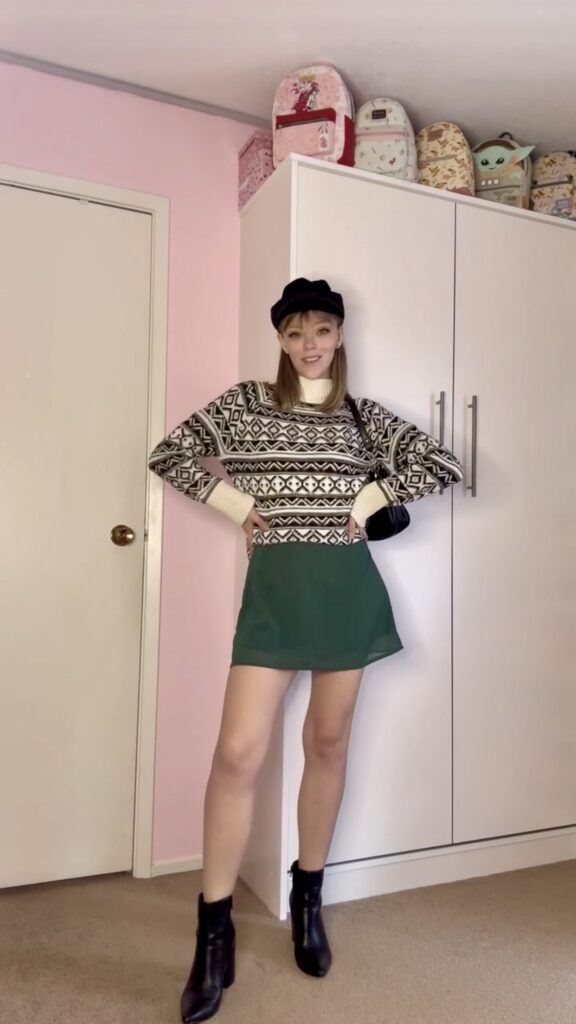 Jade wearing a thrifted striped knit sweater with green skirt and black beret, purse and boots