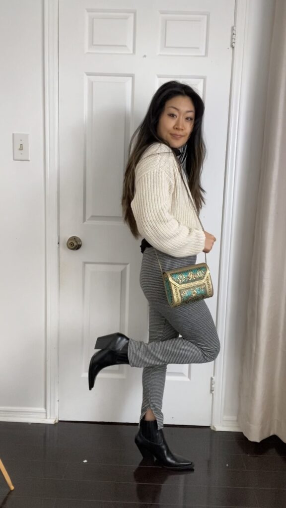 Anna wearing white knit sweater and grey leggings with green and yellow purse and black heeled boots - styled look #2