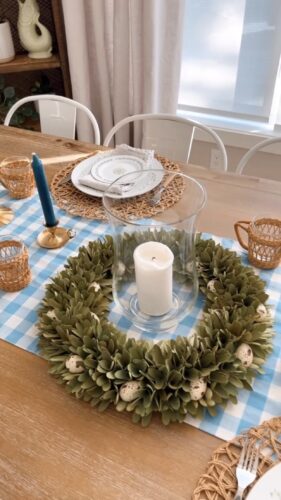 Thrifted eating table setup with egg-wreath and candle vase centerpiece