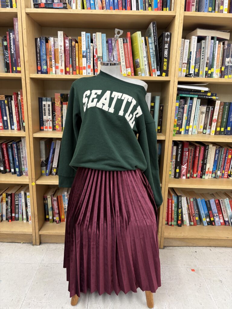 green sweater that says seattle and red pilated skirt